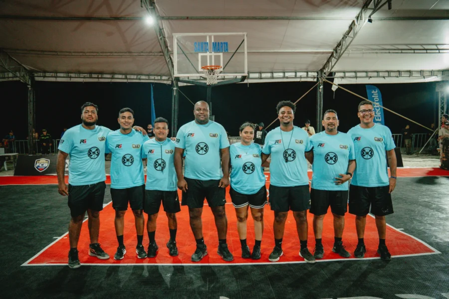 Equipo de árbitros posa sonriente en la cancha nocturna, RETO 3x3 Santa Marta 2026