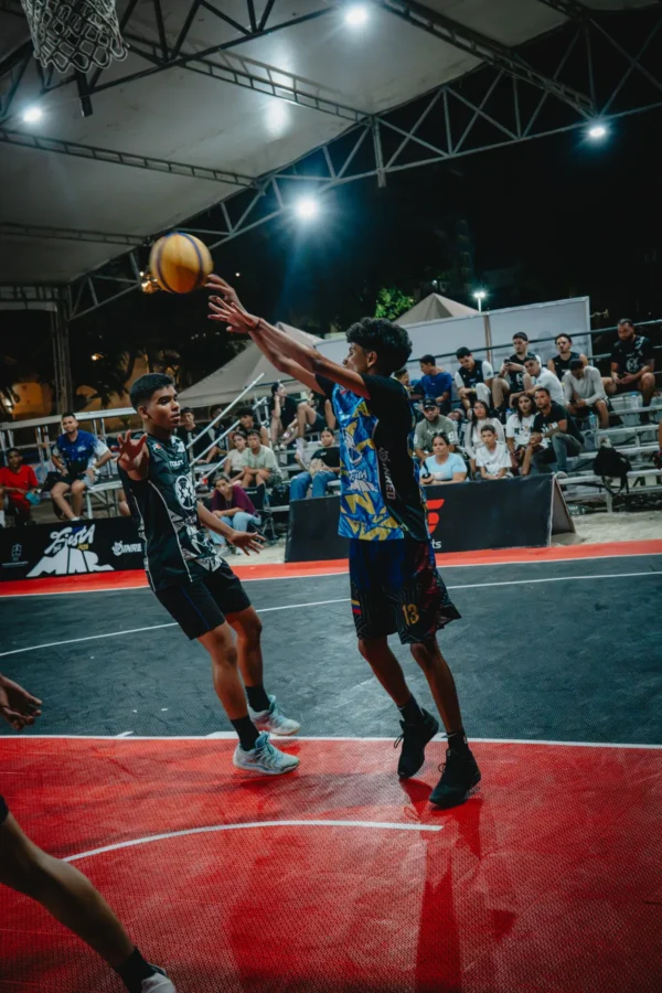 Jugador U15 lanzando a canasta bajo presión defensiva en la final nocturna, Santa Marta 2026